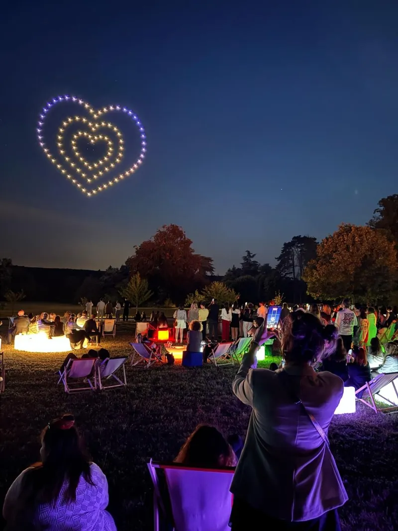 Un cœur en drones lumineux au-dessus des invités installés sur la pelouse