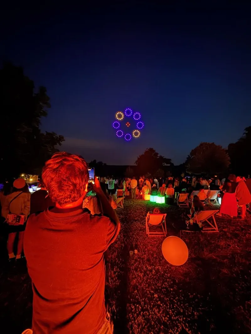 Un invité photographie le spectacle de drones lumineux au Domaine du Grand Mello