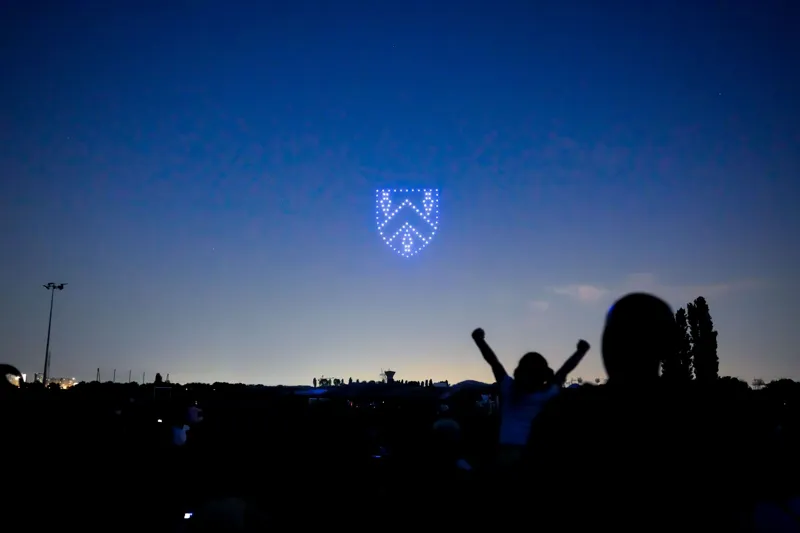 Blason de la ville de Fontenay-en-Parisis formé par les drones, une enfant lève les bras