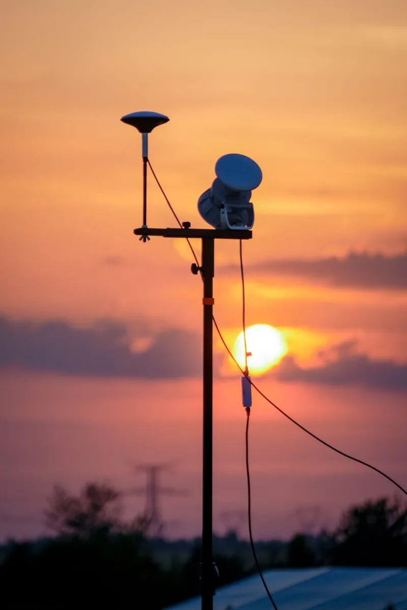 Soleil couchant derrière l'antenne de positionnement GPS du spectacle