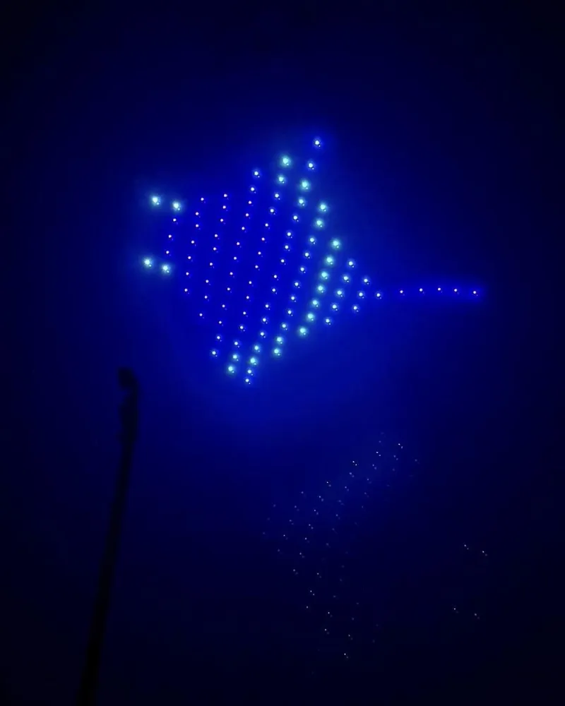 Test d'une figure en drones lumineux bleus dans la nuit