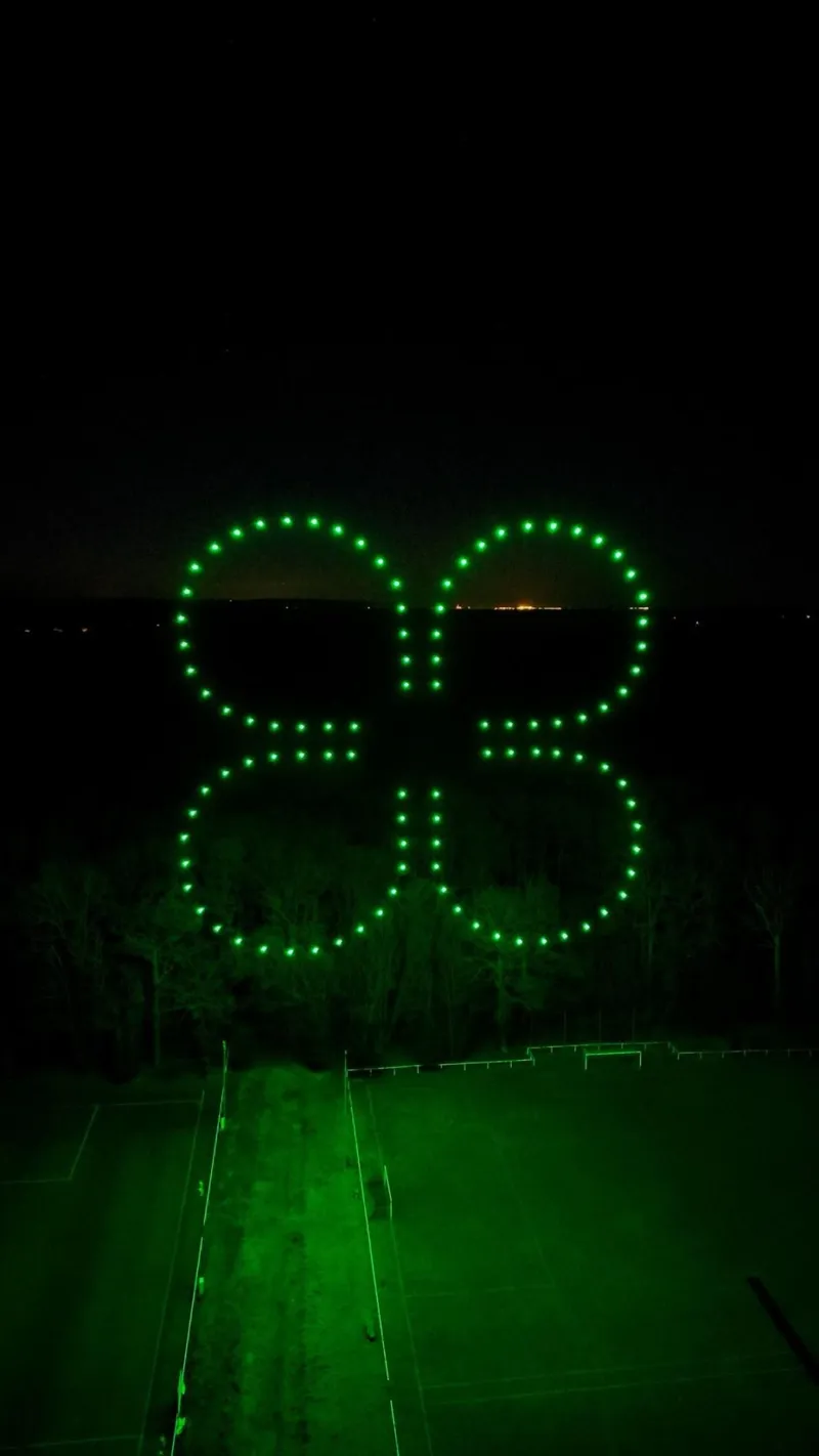 Silhouette d'un drone dessinée par des drones lumineux verts