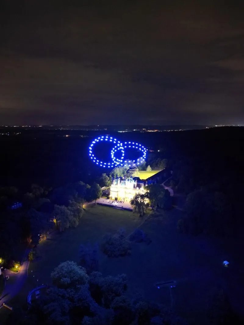 Alliances entrelacées en drones lumineux au-dessus du château