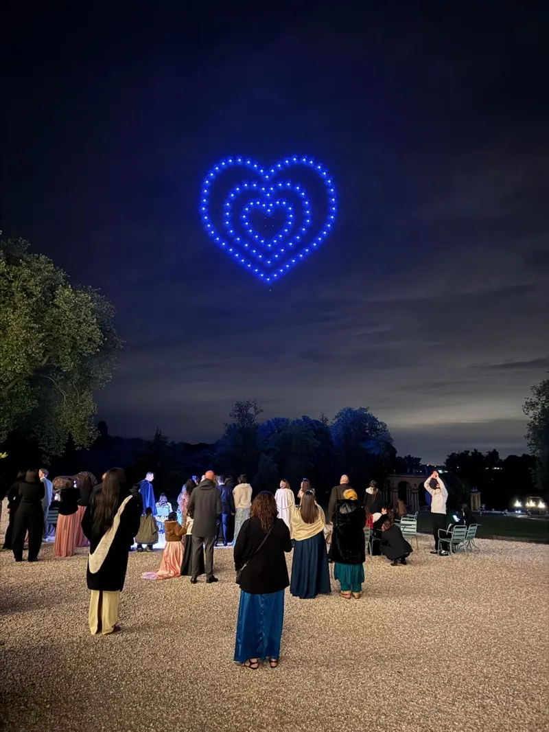 Cœur lumineux en drones bleus au-dessus des invités d'un mariage