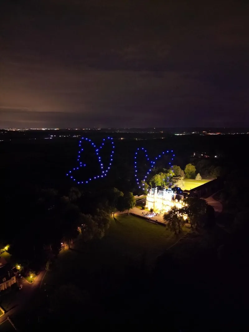 Deux papillons en drones lumineux au-dessus du Château de Saint-Martin illuminé
