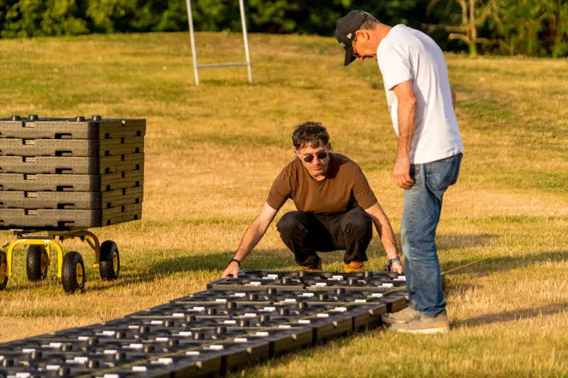 Deux pilotes Hilights déploient les drones sur la pelouse avant le spectacle