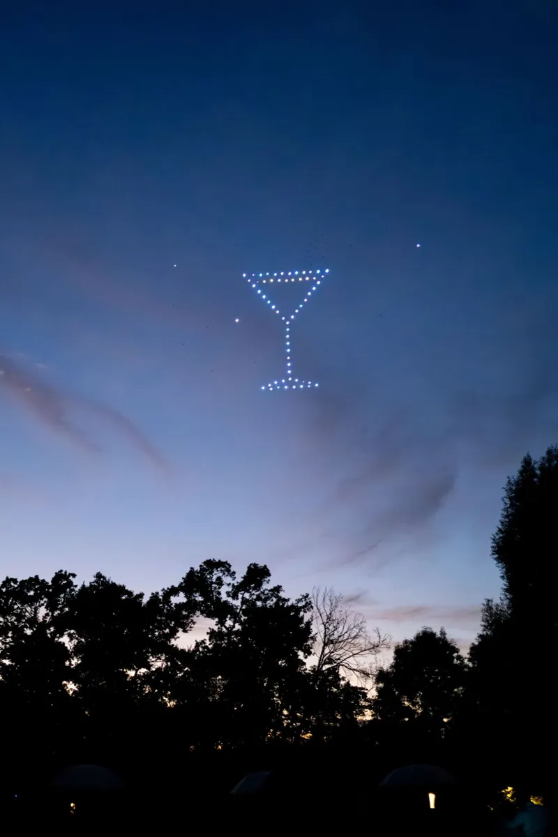 Verre à cocktail dessiné par les drones lumineux dans le ciel du soir